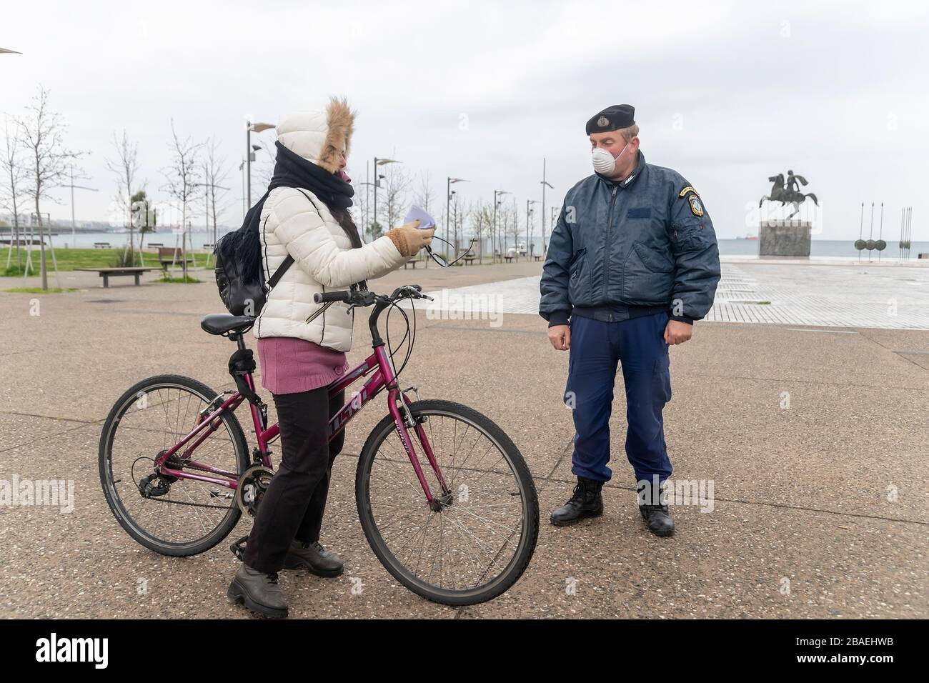 Saloniki, Griechenland - 23. März 2020: Ein Polizeibeamter überprüft die Dokumente eines Bürgers, da das Land die Verbreitung des COVID nicht unter Kontrolle hat Stockfoto