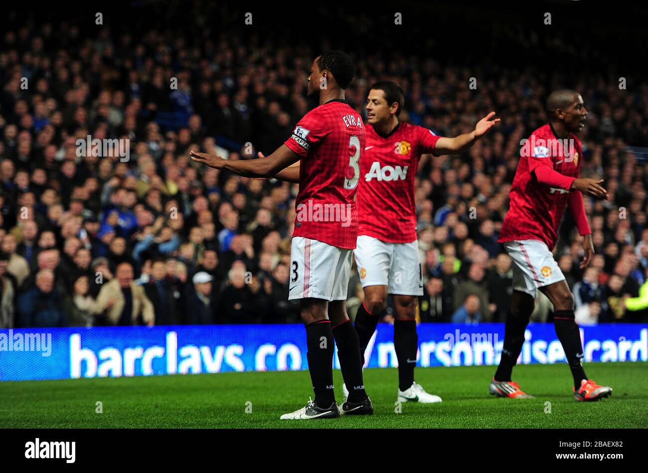 Patrice EVRA (Mitte) von Manchester United fordert die Menge auf, sich zu beruhigen, nachdem Javier Hernández (zweiter rechts) feiert, mit Teamkollege Ashley Young (rechts) das dritte Tor seiner Seite des Spiels zu erzielen. Stockfoto