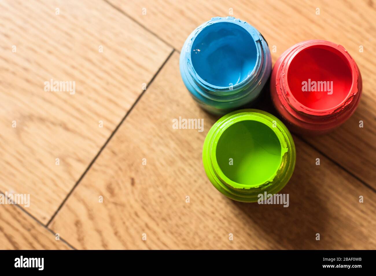 Farbige Wasserfarbenflaschen auf einem Holzboden Stockfoto