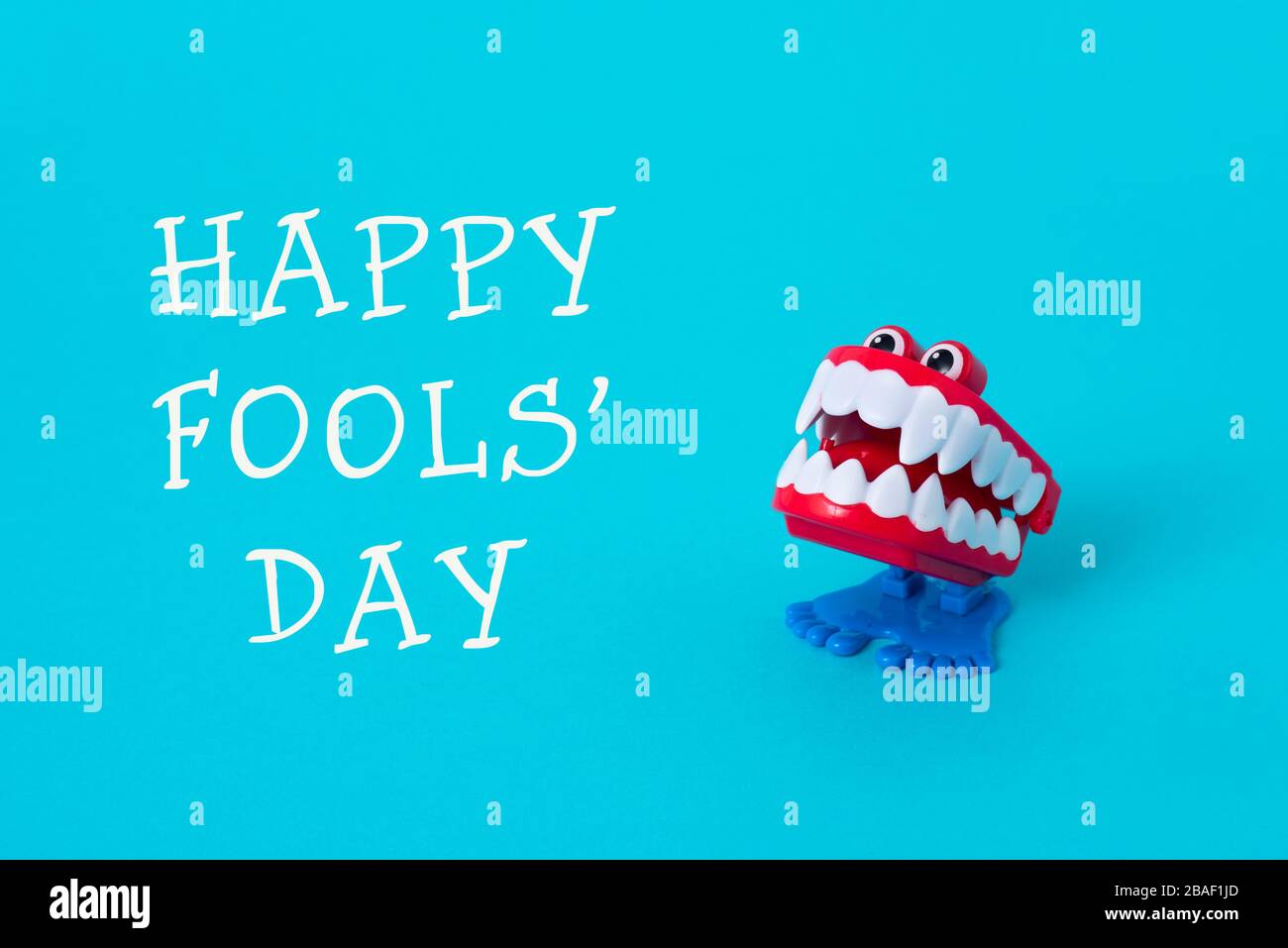 Ein lustiger Denture und der Text Happy Fools Day auf hellblauem Hintergrund Stockfoto