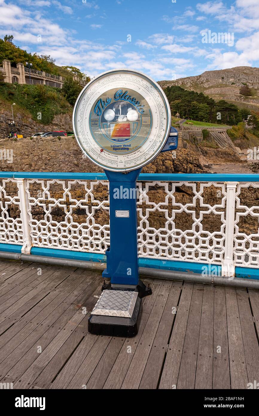 Waagen mit Vintage-Münzbetrieb auf dem Llandudno Pier, Conwy, Wales. Stockfoto