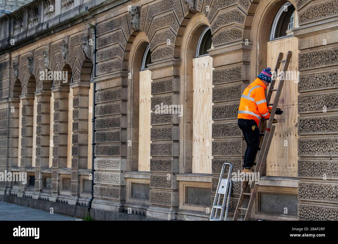 Arbeiter steigen in die Fenster eines Restaurants in Bath, Somerset, nachdem die britische Regierung strikte Einschränkungen angekündigt hatte, um Coronavirus zu versuchen und einzudämmen. Stockfoto