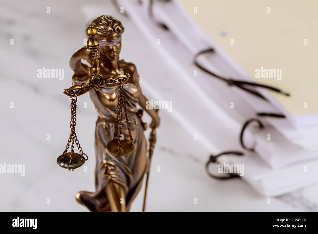 Statue der Gerechtigkeit mit Magerhaufen mit Dokumenten aus dem Justizgesetzamt Stockfoto