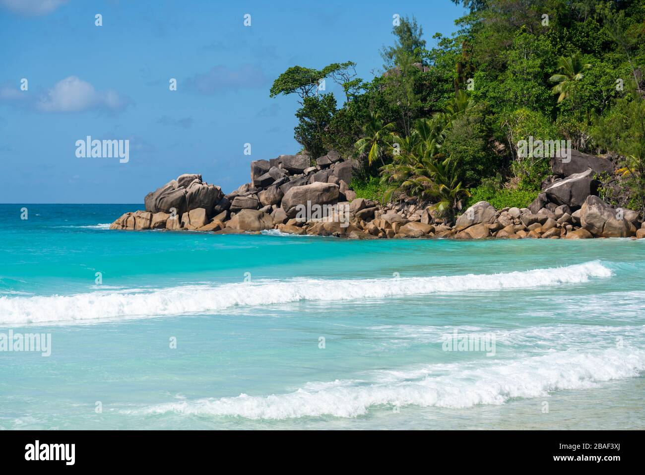Panoramablick der Drohne auf die Küste von Anse Georgette mit grünen Hügeln, türkisfarbenem Meer und tiefblauem Indischen Ozean, Praslin, Seychellen Stockfoto