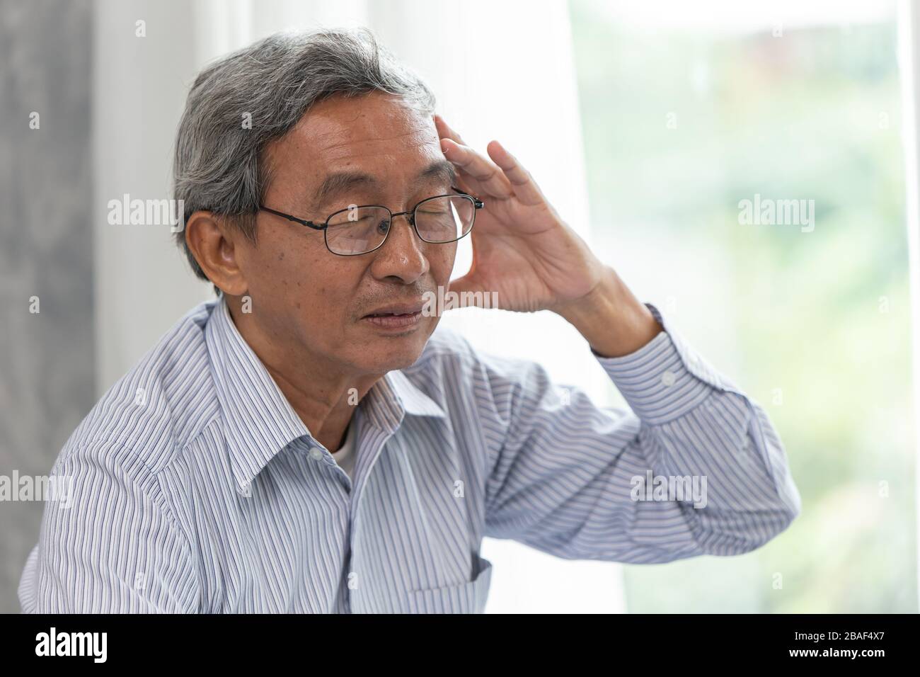 Symptome einer Erkrankung der älteren Kopfschmerzen durch tragen einer Brille. Stockfoto