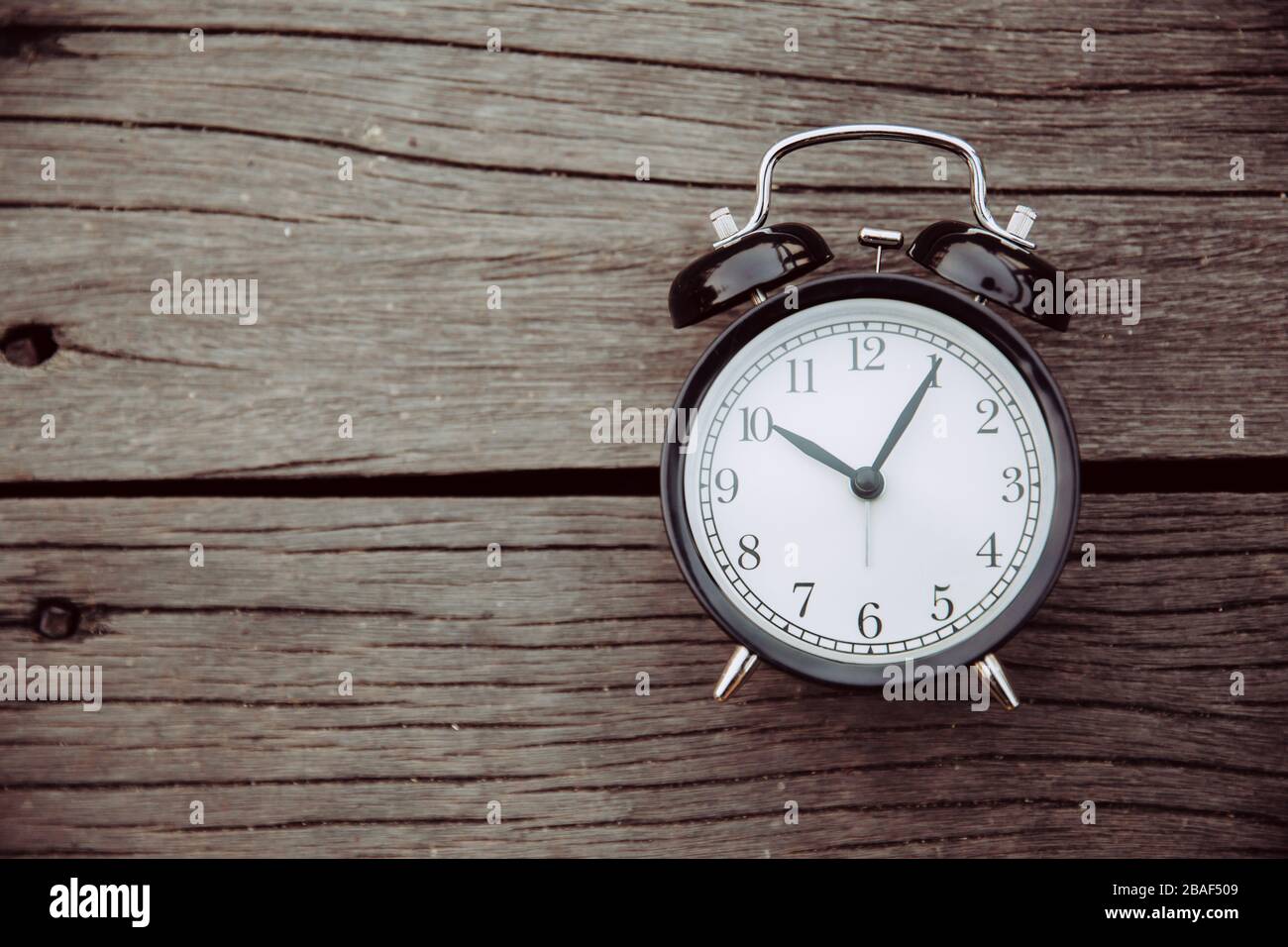 Alte Uhr auf Holzhintergrund mit Platz für Text für das Zeitgedächtniskonzept. Stockfoto