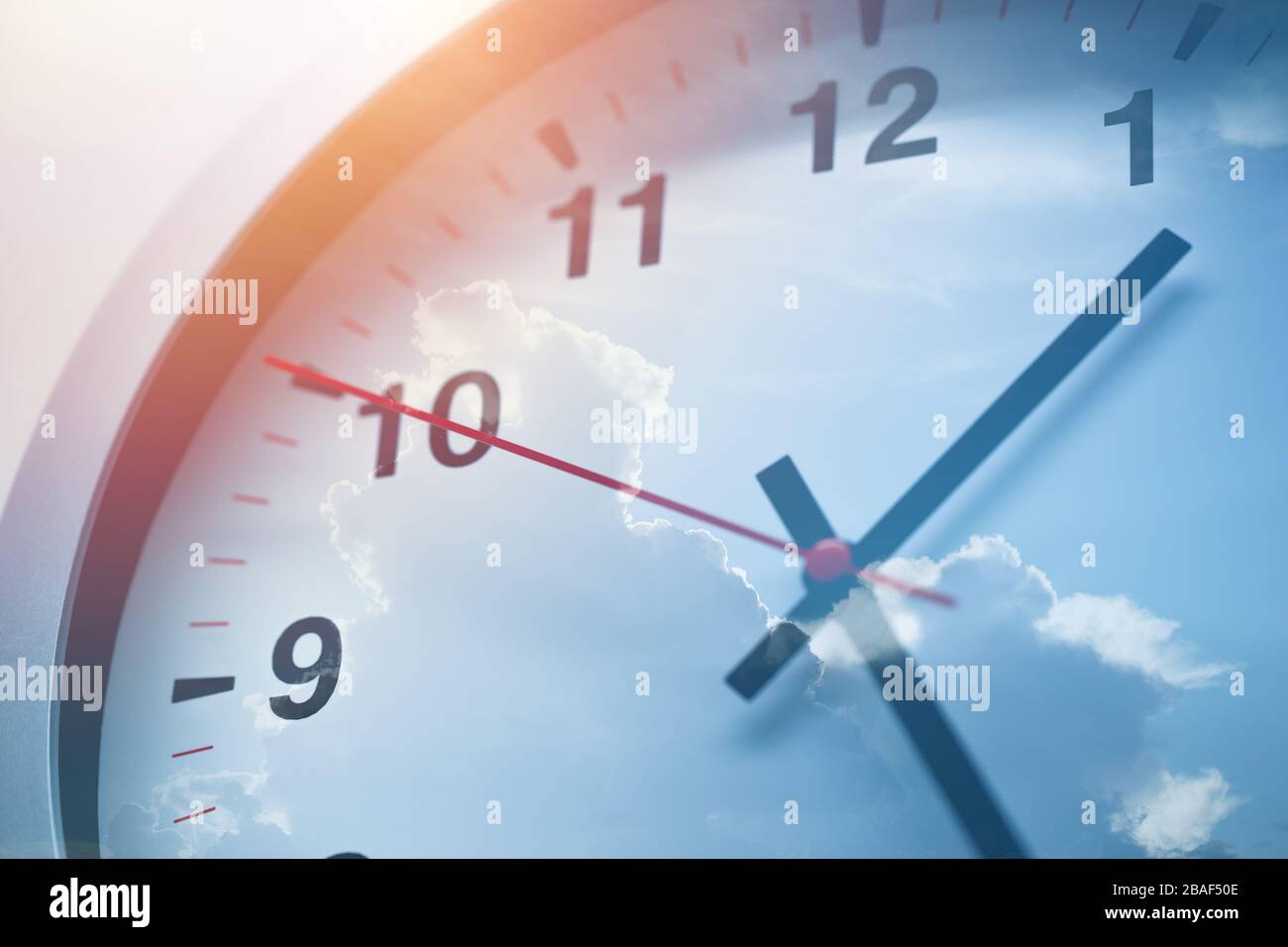 Tageszeiten Uhr überlagert Doppelbelichtung mit blauem Himmel. Stockfoto