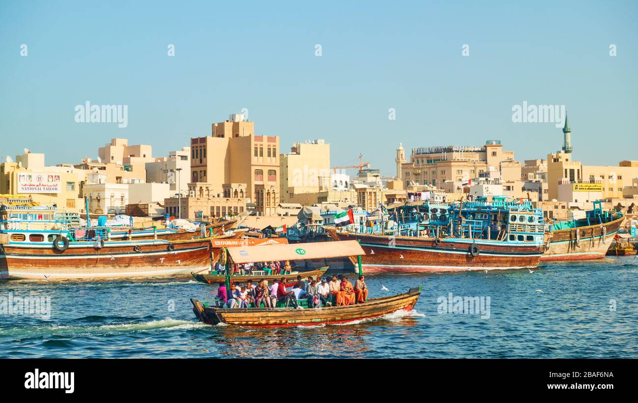 Dubai, VAE - 31. Januar 2020: Dhow-Boote an der Wharf und traditionelles ABRA-Boot mit Passanten am Creek im Deira Distrikt in Dubai, United Arab Stockfoto