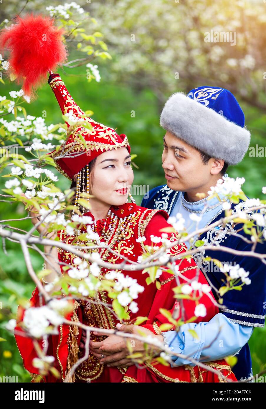 Porträt des glücklichen Paares auf Kasachisch Kostüme im Frühjahr blühen Apfel Garten Almaty, Kasachstan, Zentralasien Stockfoto