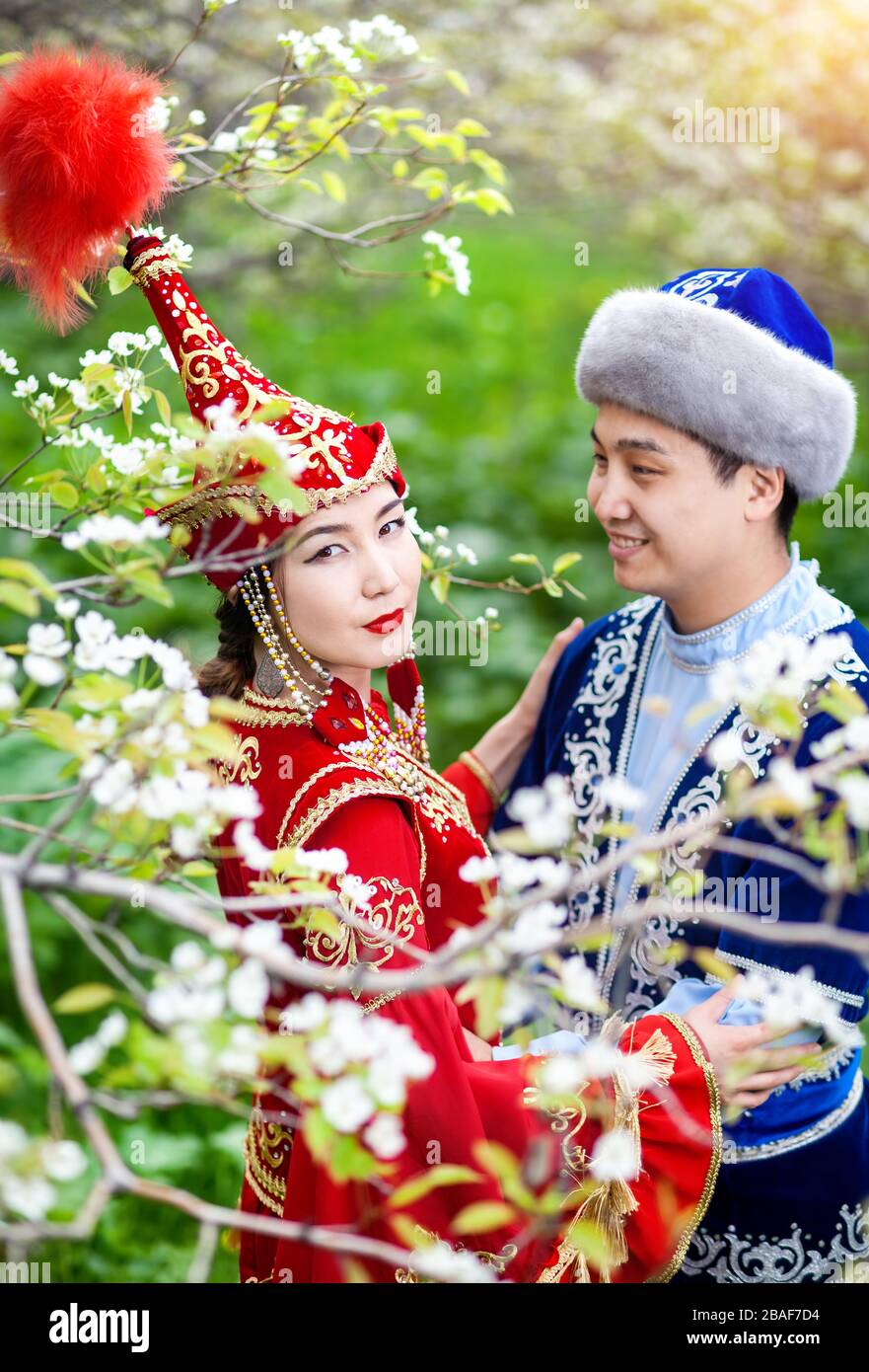 Porträt des glücklichen Paares auf Kasachisch Kostüme im Frühjahr blühen Apfel Garten Almaty, Kasachstan, Zentralasien Stockfoto