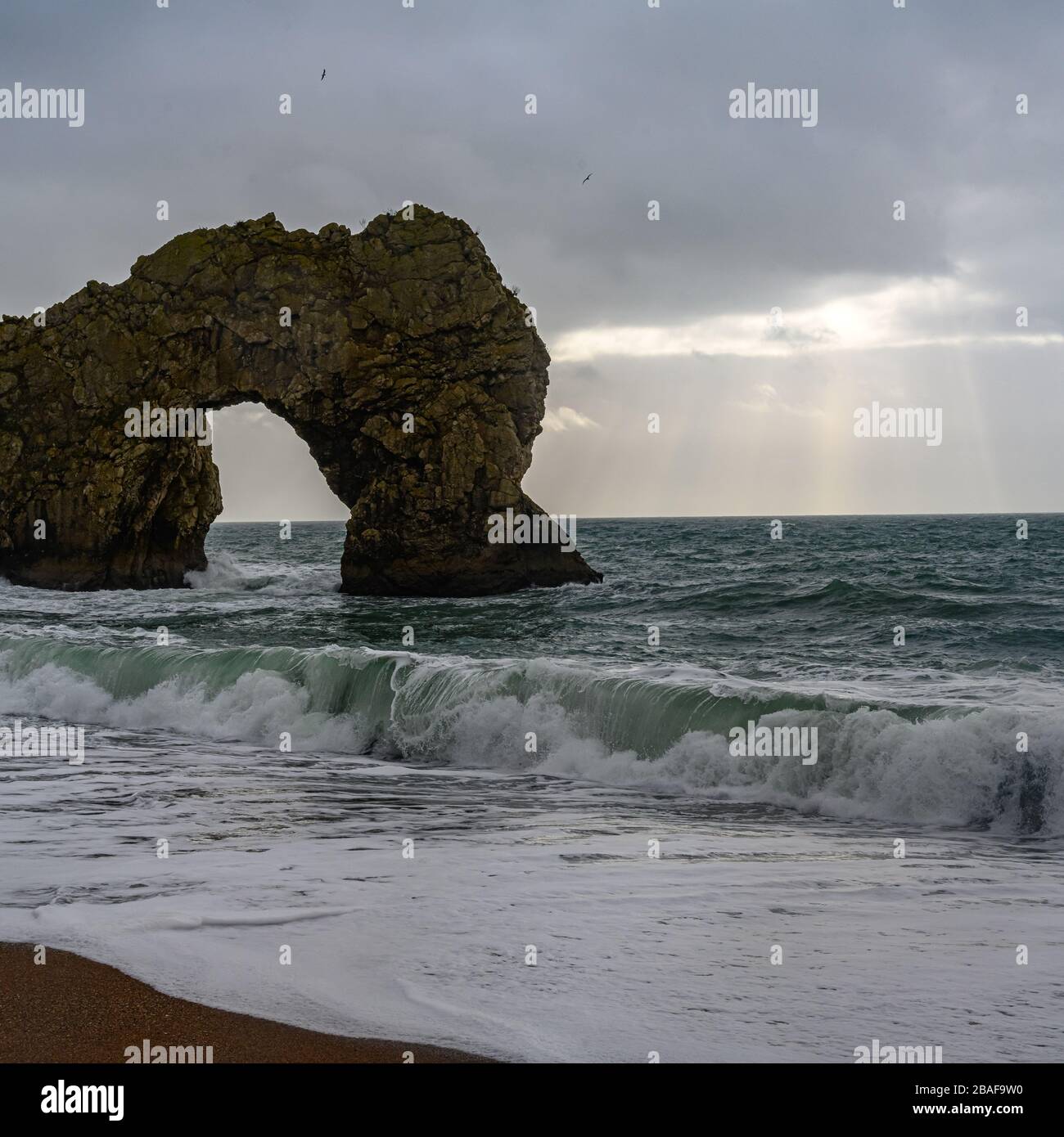 Durdle Door in Dorset strömende Wellen und ein Regensturm auf See Stockfoto