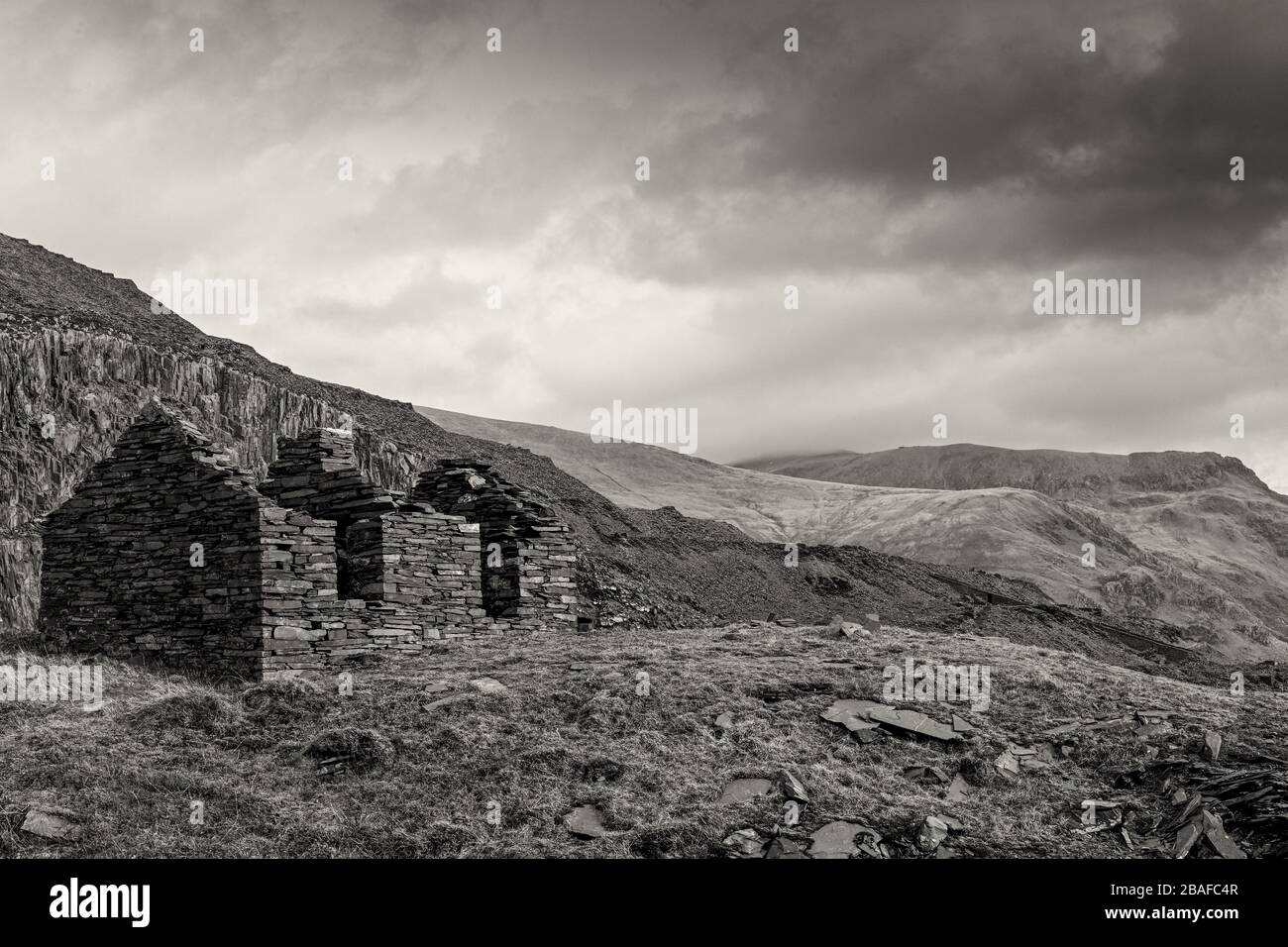 Ruinierte Bergarbeiterhäuser in Schiefersteinbruch in Snowdonia (monochrom) Stockfoto