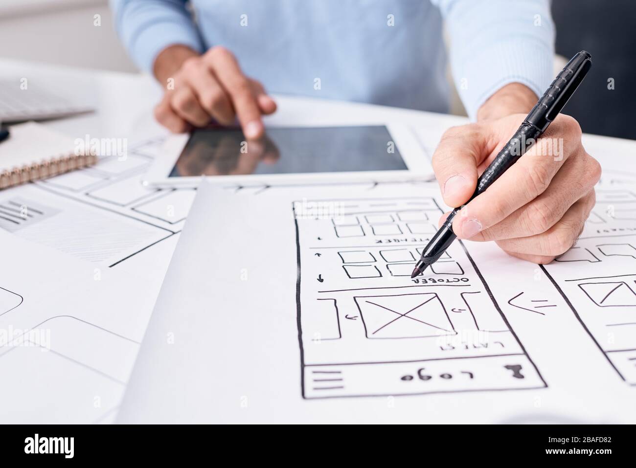 Nahaufnahme eines nicht erkennbaren UI-Engineers, der ein digitales Tablet verwendet, während er an der Entwicklung des App-Planers für Gadgets arbeitet Stockfoto