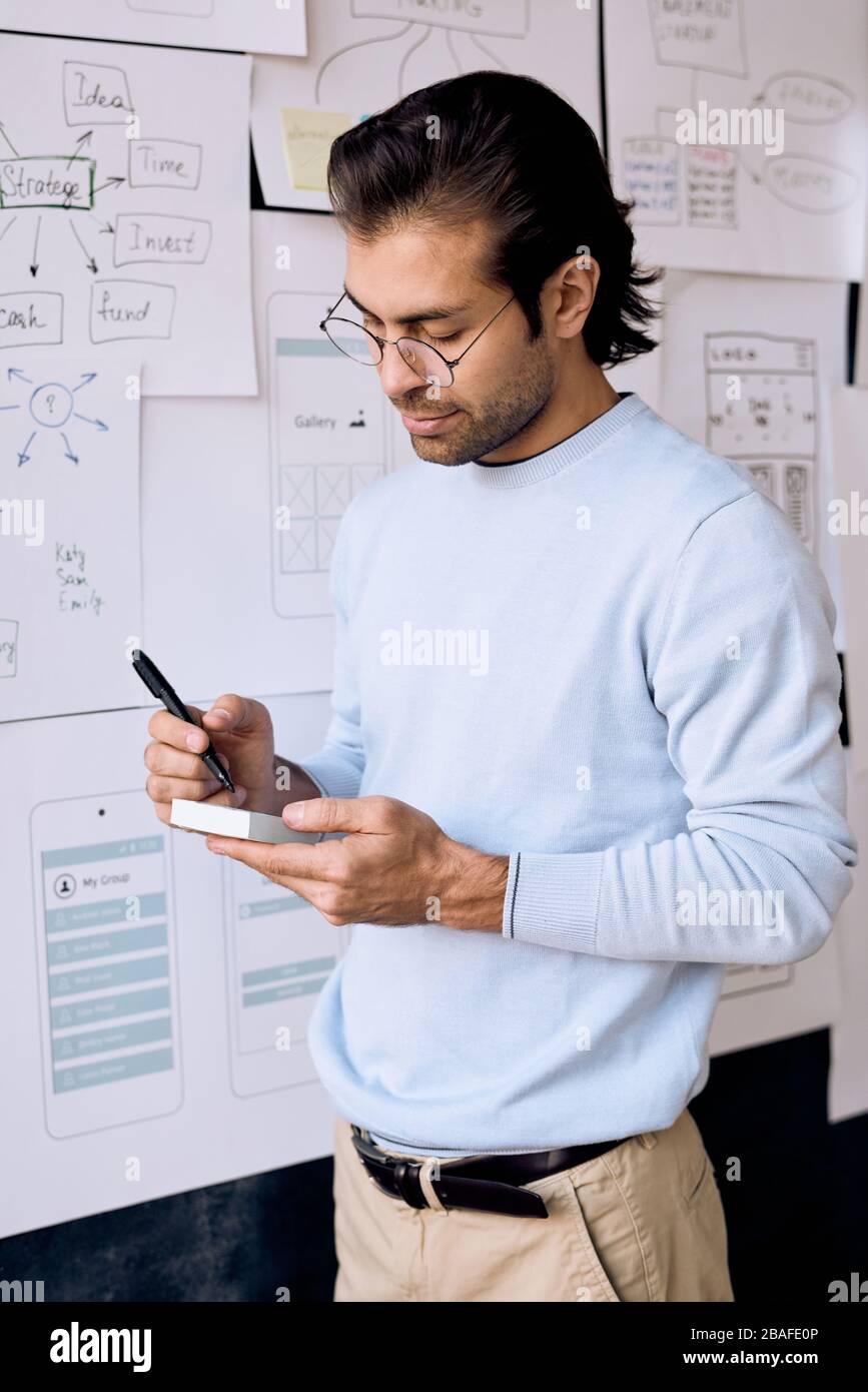 Inhalt einige Manager mittleren Alters des UI-Designunternehmens schreiben Ideen auf Haftnotizen im Büro auf Stockfoto