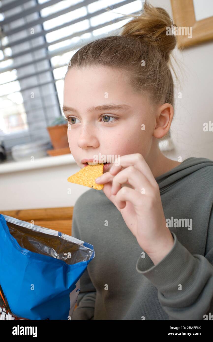 Junges Mädchen mit Dorito chip im Mund Stockfoto