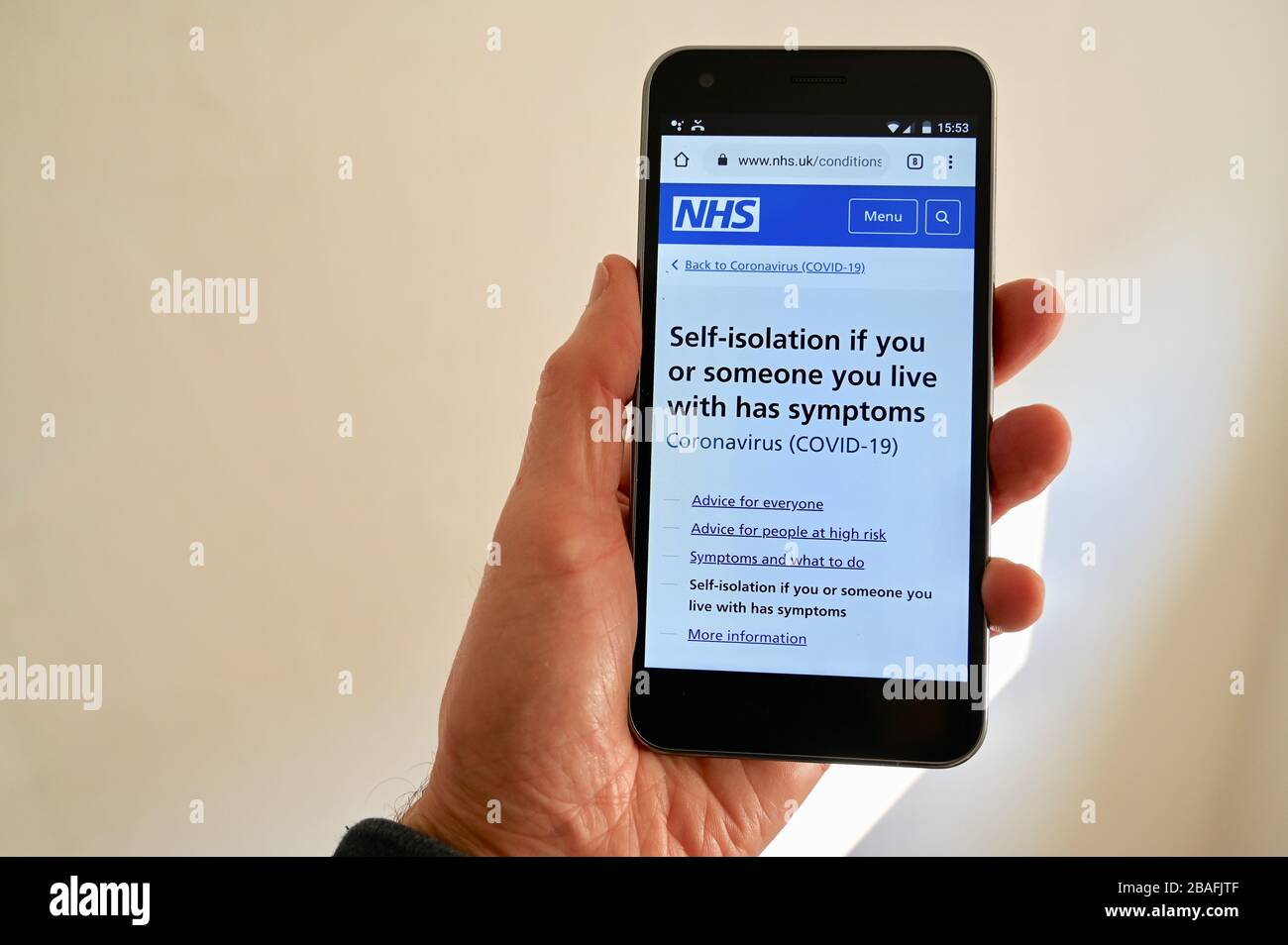 Handy mit NHS Coronavirus Ratschlag auf dem Bildschirm angezeigt. Stockfoto