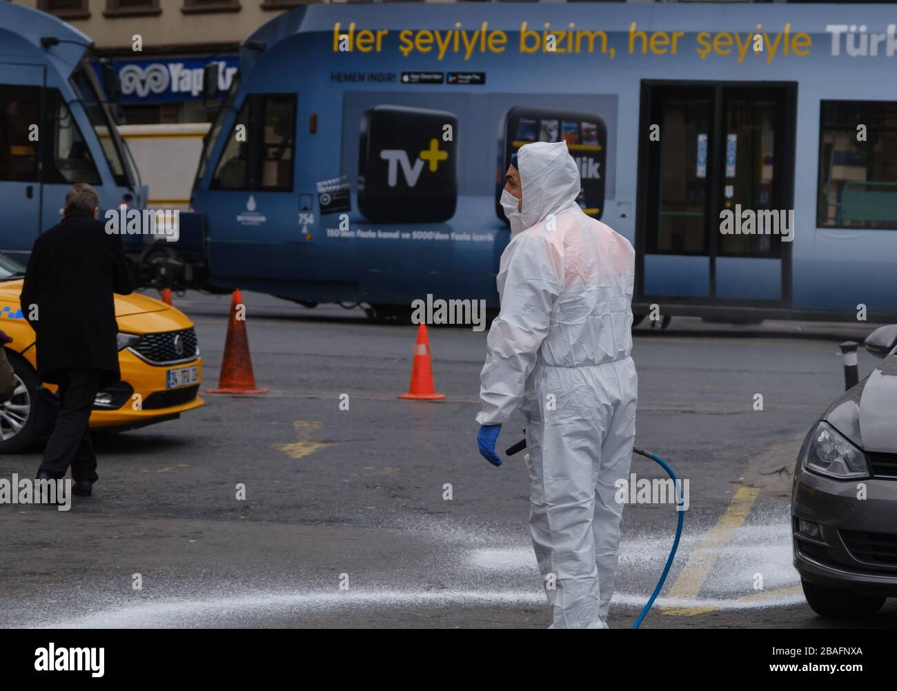 Ein Mann in Schutzausrüstung und mit einer Maske und einer Reinigung desinfizieren die Straßen in istanbul gegen das Coronavirus. Stockfoto
