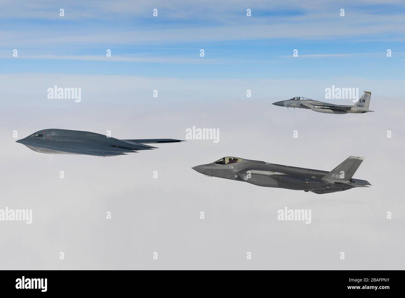 Ein Kampfflugzeug der Royal Netherlands Air Force F-35A Stealth-Kampfflugzeug und ein Kampfflugzeug der U.S. Air Force F-15C Eagle fliegen in Formation und eskortieren einen B-2A Spirit Bomber, der dem 509th Bomb Wing zugeordnet ist, während Luftoperationen zur Unterstützung der Bomber Task Force Europe 20./2. März 2020 über der Nordsee. Stockfoto