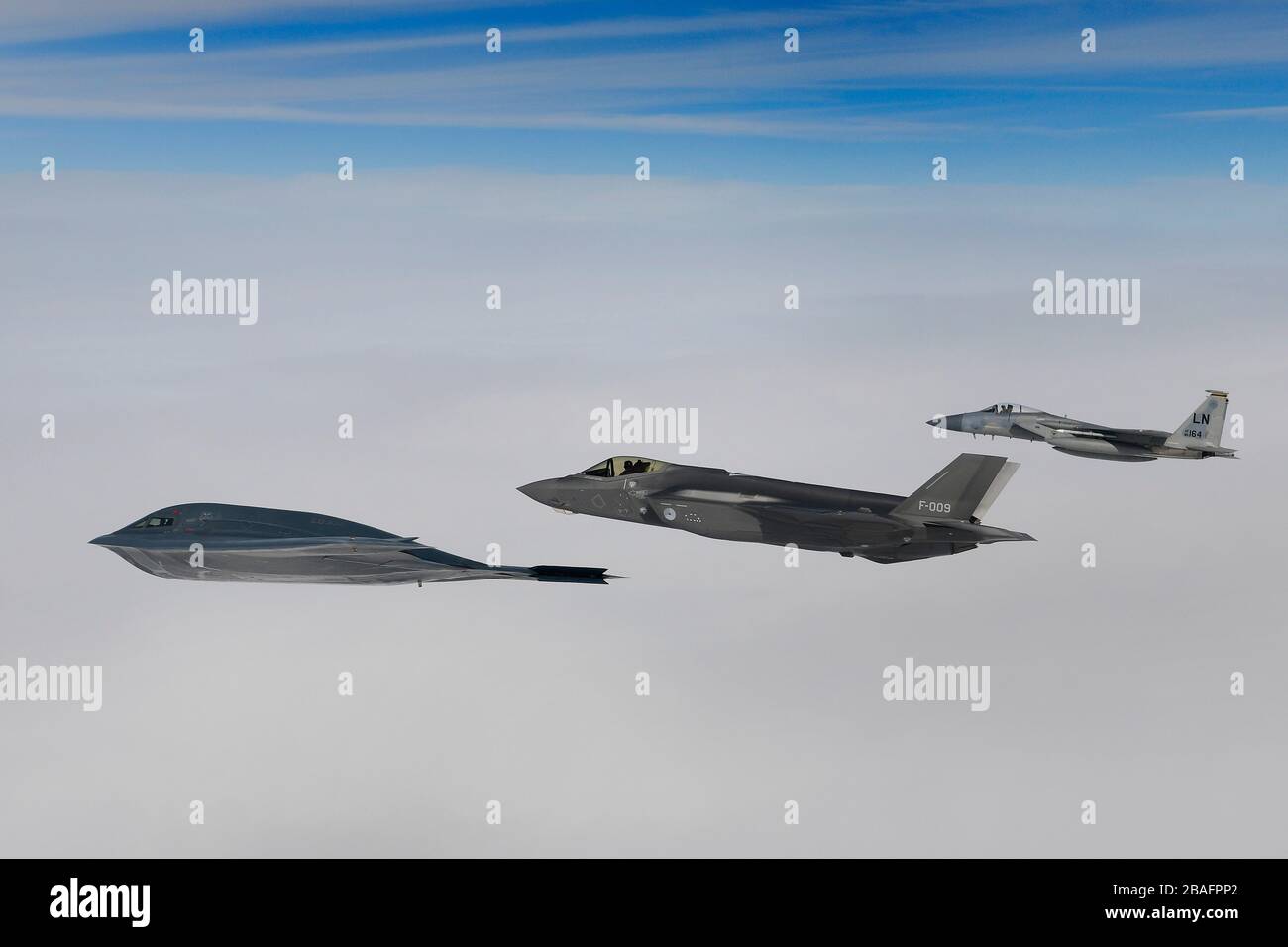Ein Kampfflugzeug der Royal Netherlands Air Force F-35A Stealth-Kampfflugzeug und ein Kampfflugzeug der U.S. Air Force F-15C Eagle fliegen in Formation und eskortieren einen B-2A Spirit Bomber, der dem 509th Bomb Wing zugeordnet ist, während Luftoperationen zur Unterstützung der Bomber Task Force Europe 20./2. März 2020 über der Nordsee. Stockfoto