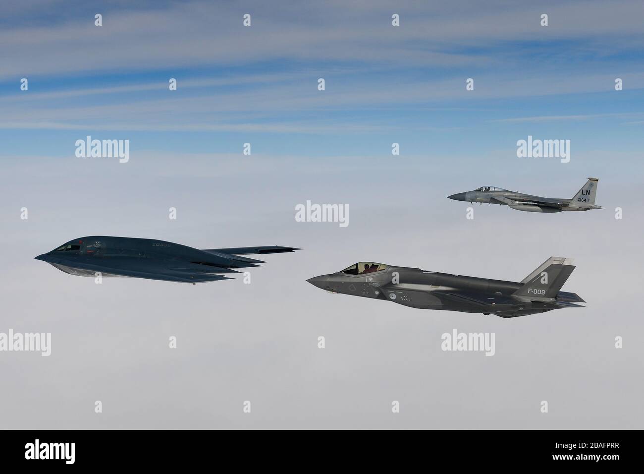 Ein Kampfflugzeug der Royal Netherlands Air Force F-35A Stealth-Kampfflugzeug und ein Kampfflugzeug der U.S. Air Force F-15C Eagle fliegen in Formation und eskortieren einen B-2A Spirit Bomber, der dem 509th Bomb Wing zugeordnet ist, während Luftoperationen zur Unterstützung der Bomber Task Force Europe 20./2. März 2020 über der Nordsee. Stockfoto