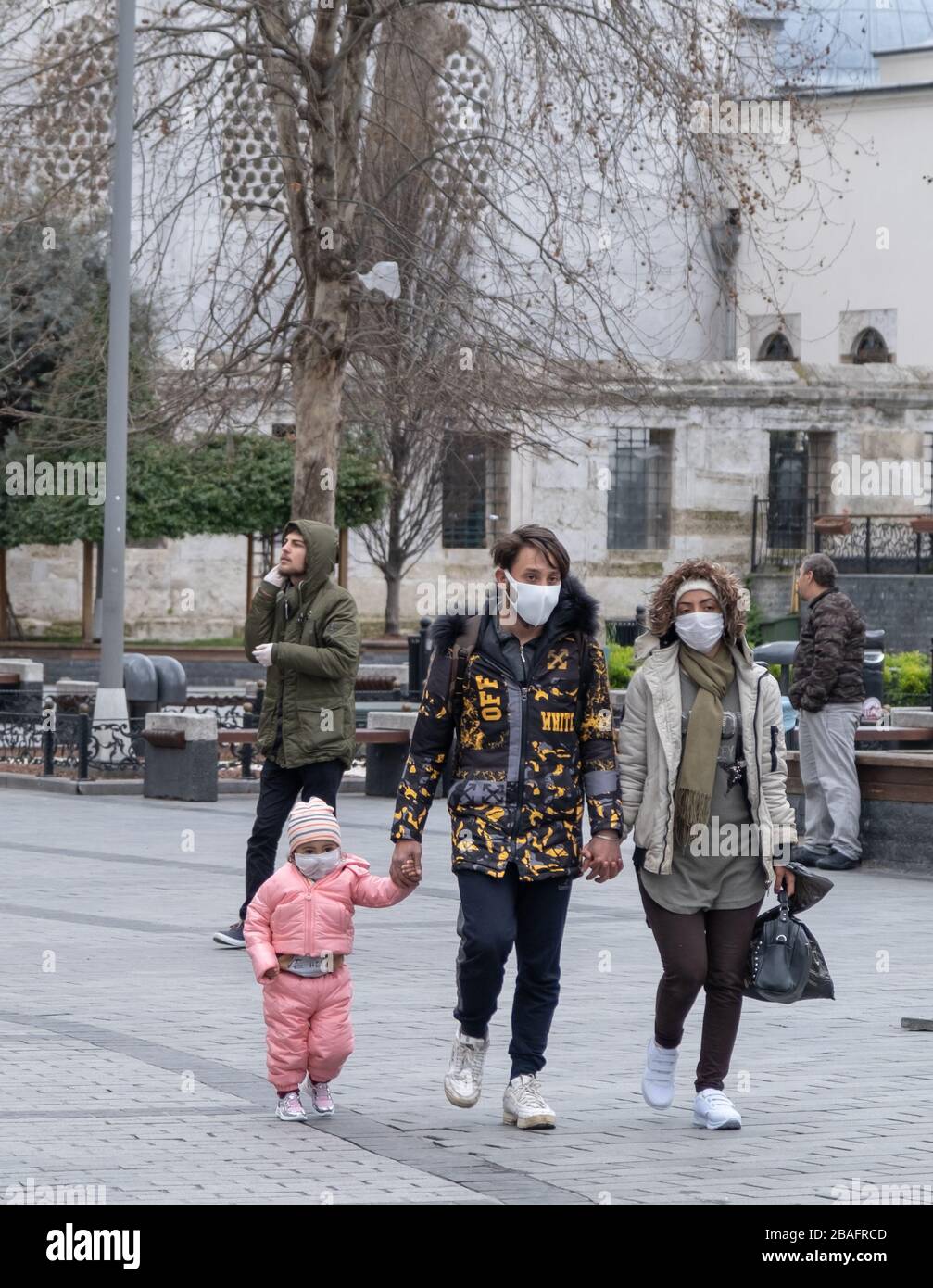 Istanbul, Türkei, Eltern mit einem Kind, das Gesichtsmasken trägt, um sich vor Corona-Viren (COVID-19) zu schützen, die auf der leeren Straße herumlaufen Stockfoto