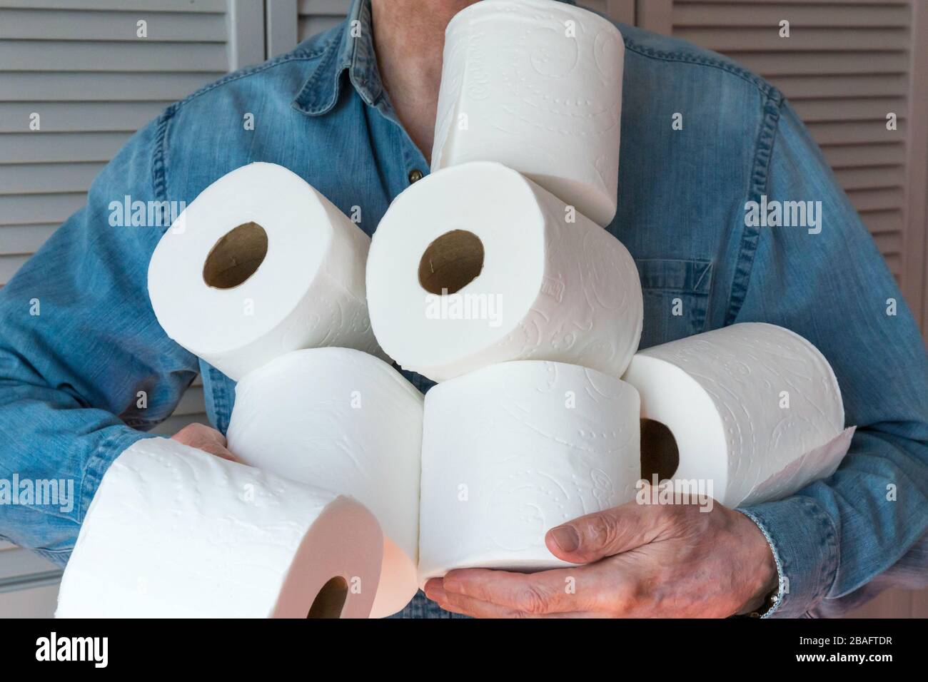 Mann, der während der Pandemie von Coronavirus, USA, zusätzliche Rollen Toilettenpapier hält Stockfoto