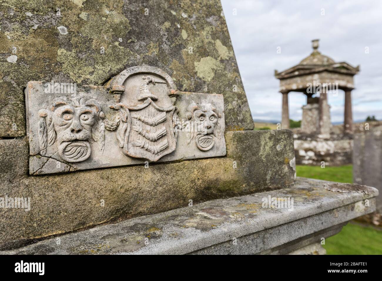 Geschnitzte Gesichter und Wappen auf dem Grabstein des Obelisken, Old Castleton Cemetery, Newcastleton, St Martin's Churchyard, Byerholm, Castleton, Roxburghshire, Scotlan Stockfoto