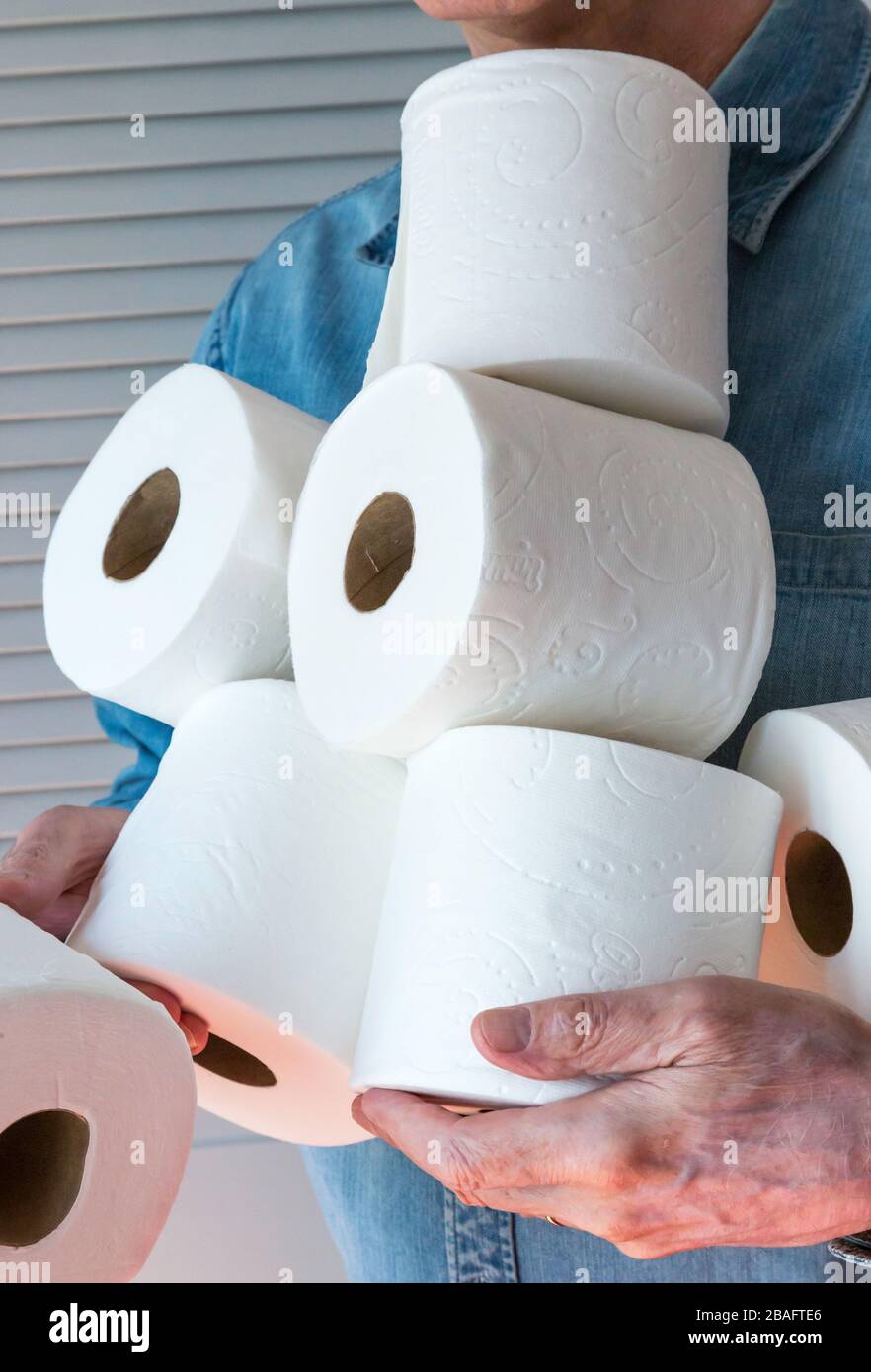Mann, der während der Pandemie von Coronavirus, USA, zusätzliche Rollen Toilettenpapier hält Stockfoto