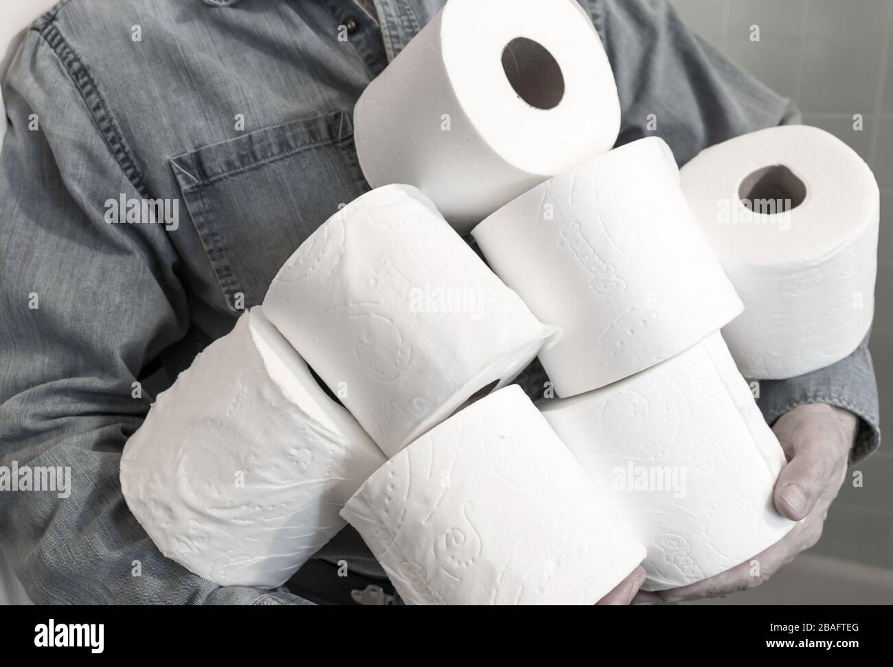 Mann, der während der Pandemie von Coronavirus, USA, zusätzliche Rollen Toilettenpapier hält Stockfoto