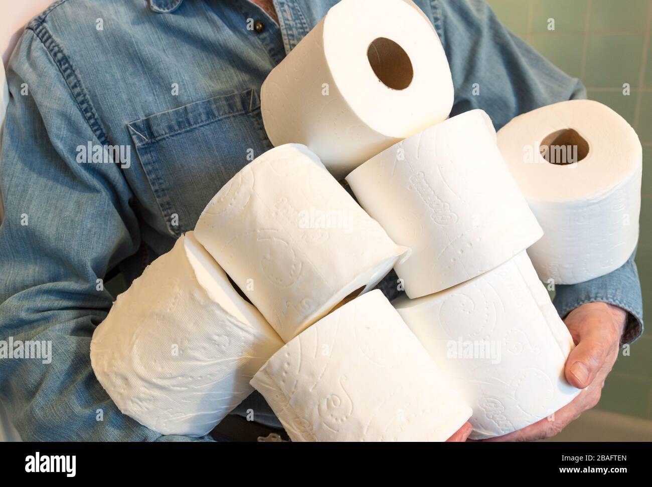 Mann, der während der Pandemie von Coronavirus, USA, zusätzliche Rollen Toilettenpapier hält Stockfoto