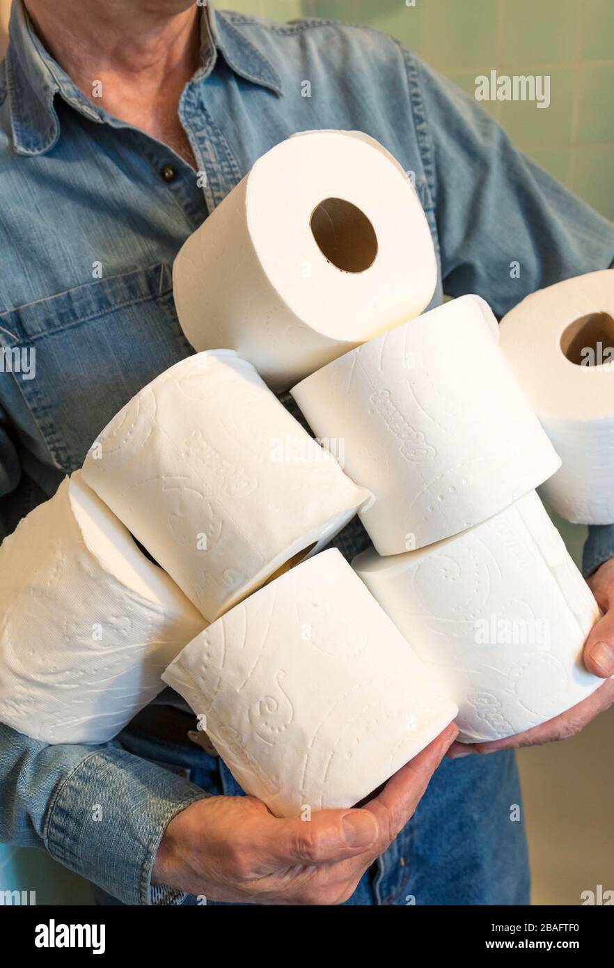 Mann, der während der Pandemie von Coronavirus, USA, zusätzliche Rollen Toilettenpapier hält Stockfoto
