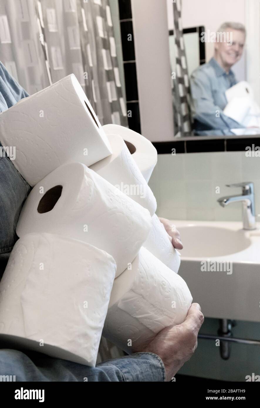 Leitender Mann, der während der Pandemie von Coronavirus, USA, zusätzliche Rollen Toilettenpapier hält Stockfoto
