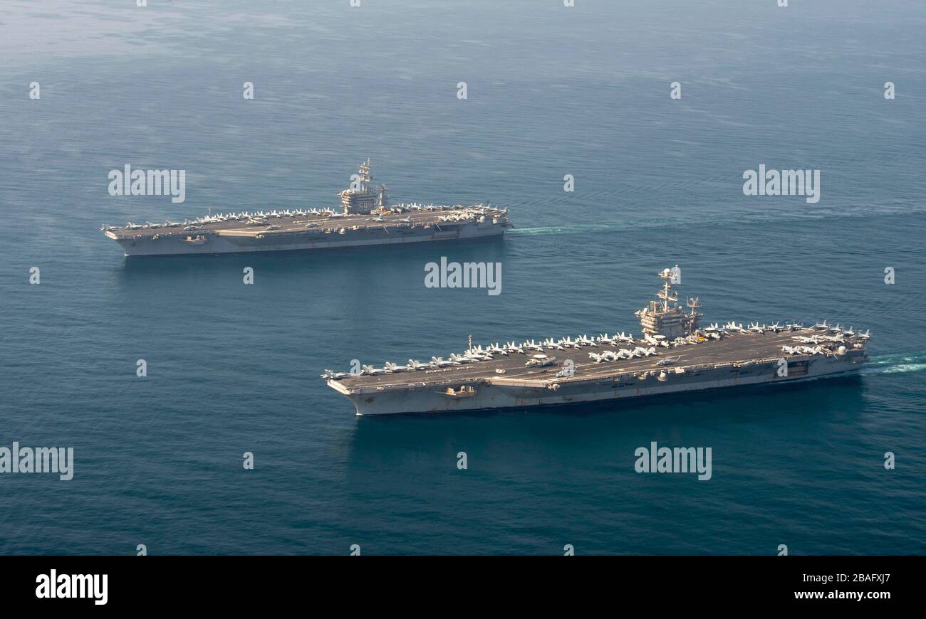 Die Flugzeugträger der Nimitz-Klasse der US-Marine, USS Dwight D. Eisenhower, verließen und USS Harry S. Truman transiten Seite an Seite in der Formation am 18. März 2020 im Arabischen Meer. Stockfoto