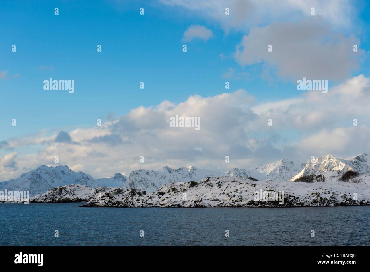 Winterszene mit Blick auf das Norwegische Meer und schneebedeckte Berge in der Nähe von Henningsvaer, einem kleinen Fischerdorf in der Nähe von Svolvaer, im Lofoten Stockfoto