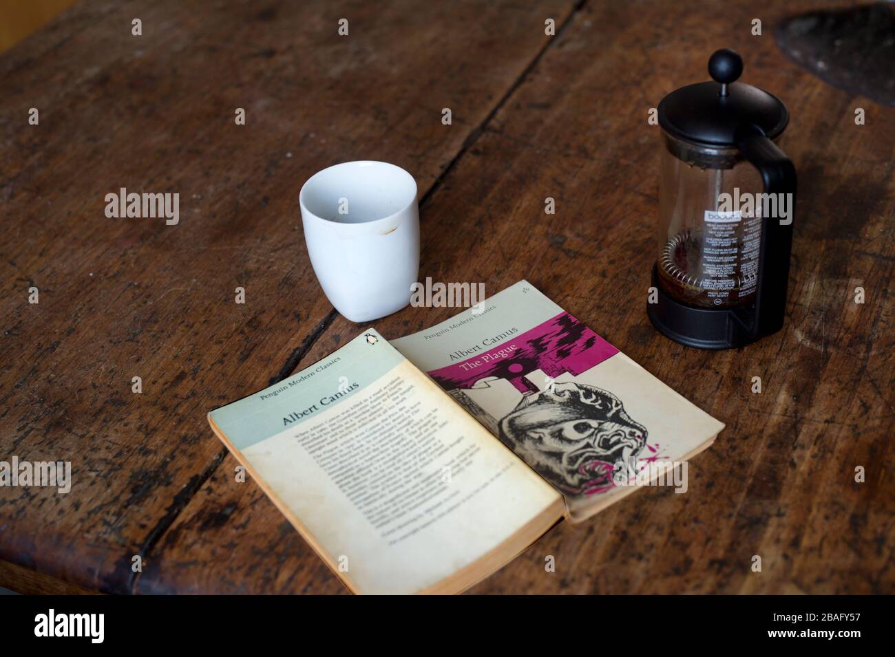 Hackney, London, England, Großbritannien. Corona Virus (Covid-19) Pandemie. Kopie von "The Plague" von Albert Camus und Kaffeekafetetiere. Stockfoto