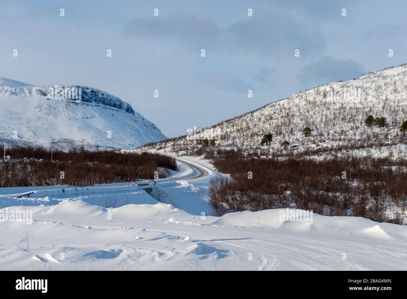 Blick auf die Straße E 10 entlang des Tornetrask im Winter im schwedischen Lappland, Nordschweden. Stockfoto