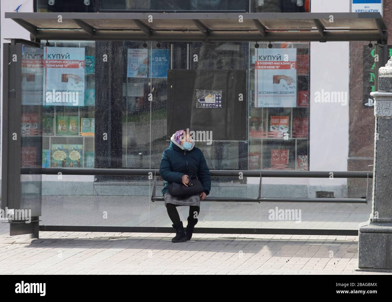 Eine Frau, die eine Gesichtsschutzmaske als präventive Maßnahme gegen die COVID-19-Coronavirus-Sitze an einer Bushaltestelle in Kiew trägt.die ukrainische Regierung führte einen nationalen Notfall für 30 Tage ein und verlängert die Quarantäne gegen die Verbreitung des COVID-19-Coronavirus in der Ukraine bis zum 24. April 2020. Ab 10:00 Uhr am 27. März 2020 gab es 218 vom Labor bestätigte COVID-19-Fälle in der Ukraine, von denen 5 tödlich waren und 4 sich erholten. Im Laufe des Tages wurden 62 neue Fälle in der Ukraine verzeichnet. Stockfoto