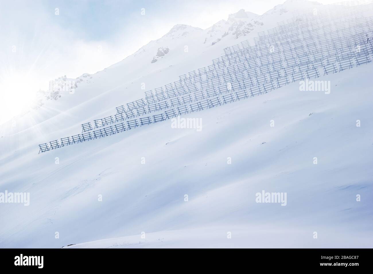 Hanglage mit Schneekäunen zur Lawinenkontrolle. Stockfoto