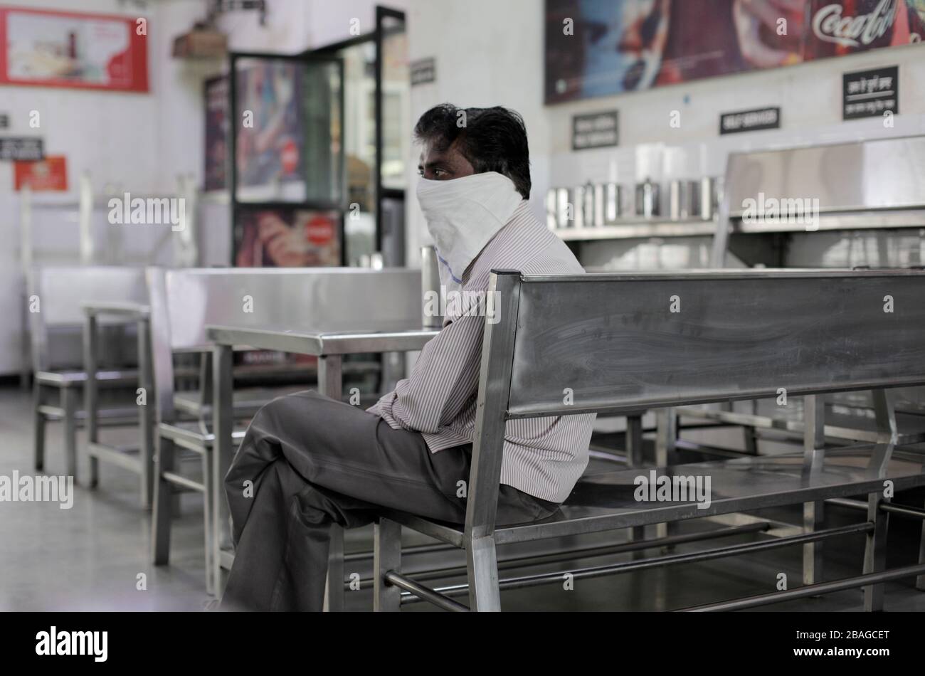 Ein Mann, der einen Schal als Maske trägt, sitzt in einem leeren Restaurant. Während die Schulen und Universitäten wegen der Kovid 19 vom 16. März an geschlossen sind, sind die Restaurants der Studenten leer. Die Zahl der Todesopfer steigt auf 20 und die bestätigten Fälle auf 863. Stockfoto