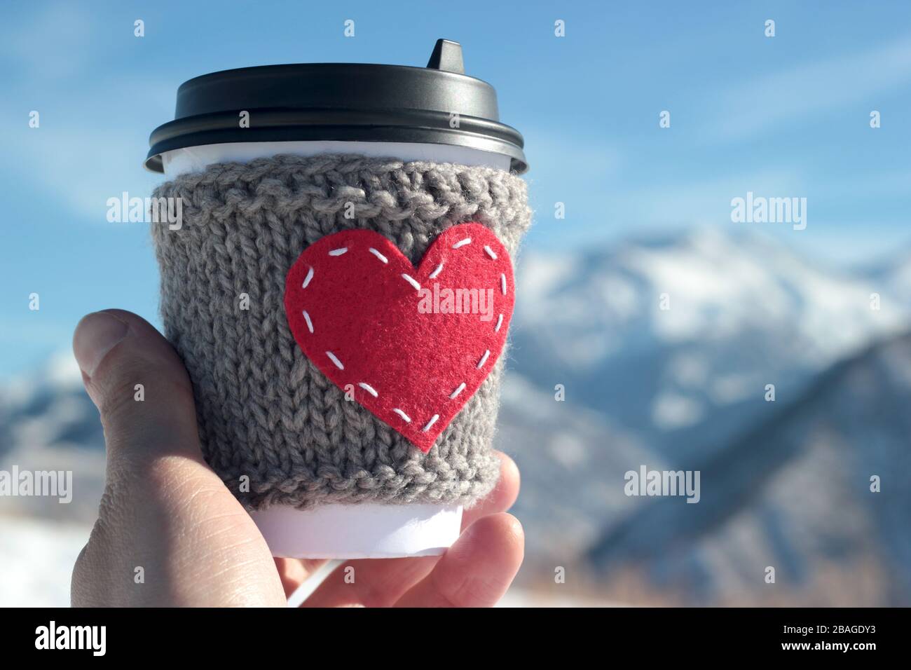 Strickkaffeetasse im roten Herzen, gemütlich Stockfoto