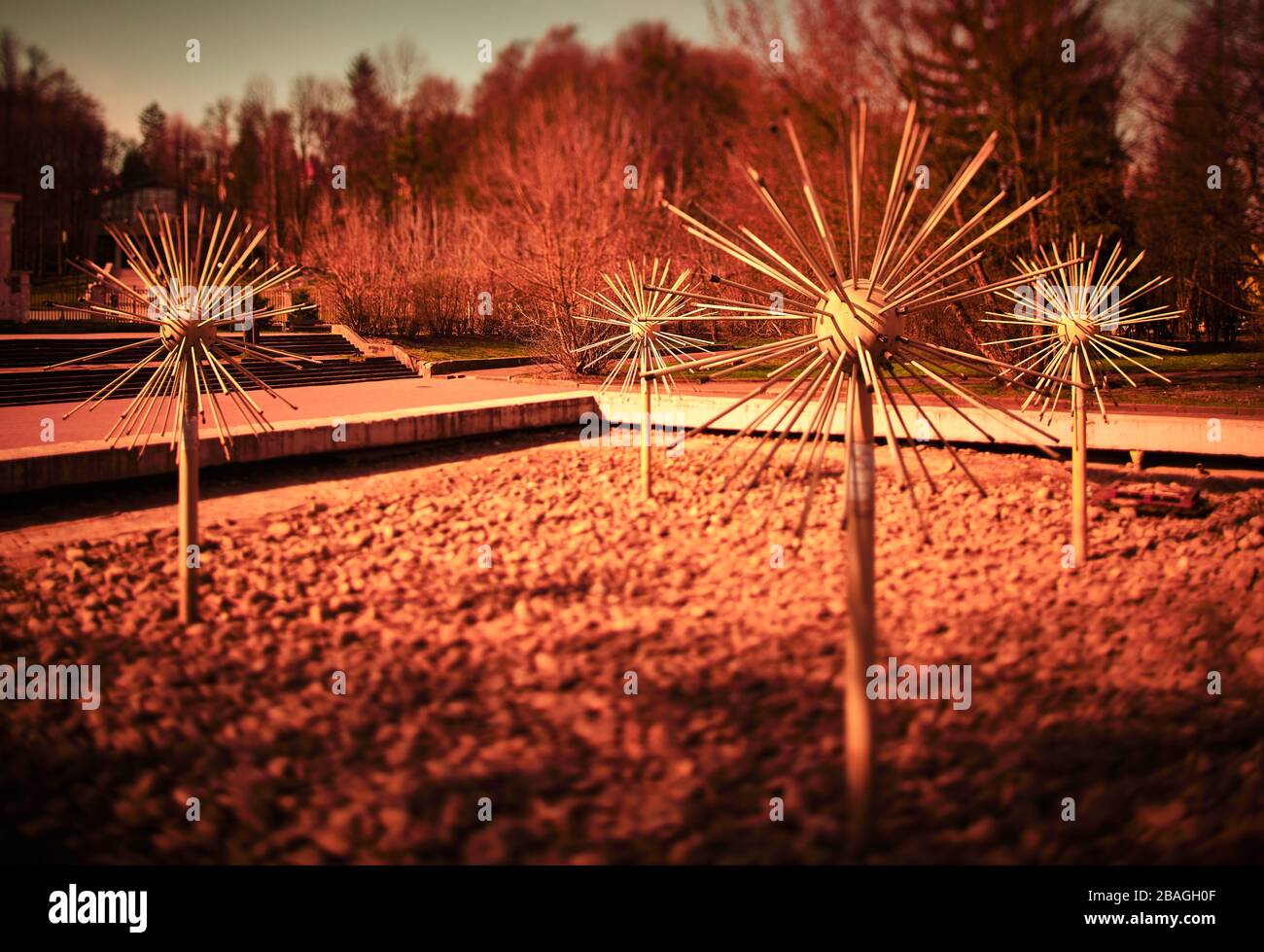 Diese Objekte ähneln einem Coronavirus. Foto mit rotem Filter. Es ist ein alter sowjetischen Brunnen Stockfoto