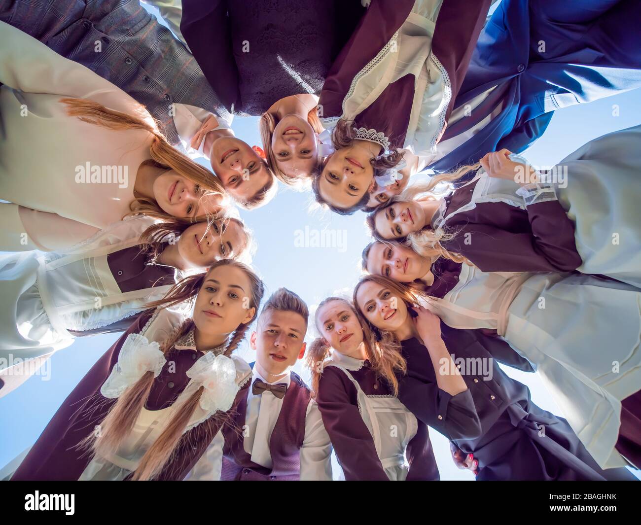 Eine Gruppe von Abiturienten im Kreis blickt nach unten. Das Konzept der freundlichen Studenten. Stockfoto