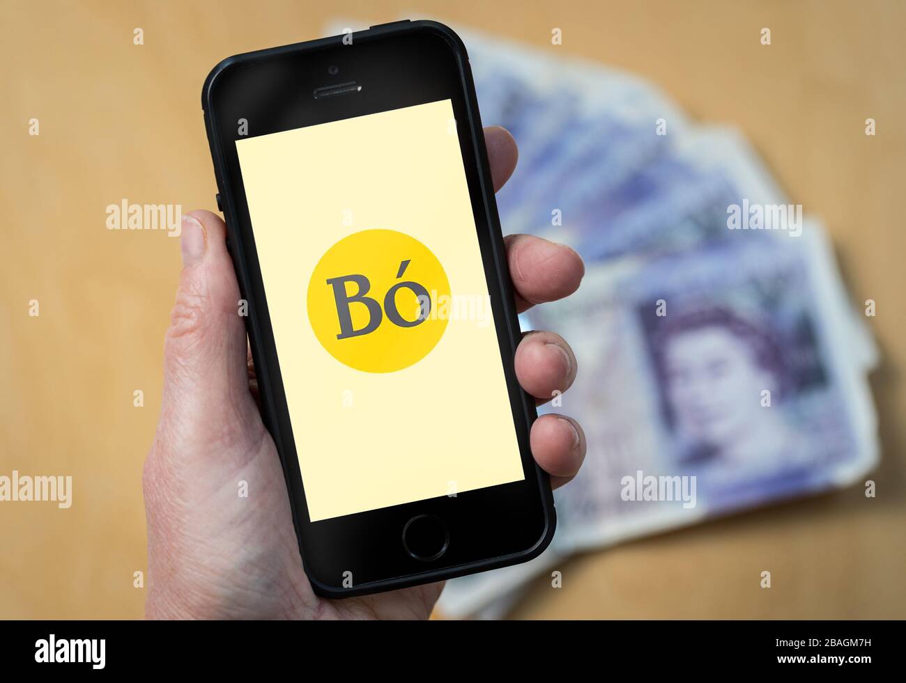 Eine Frau, die das Logo der Bo Banking App auf einem Mobiltelefon betrachtet. (Nur redaktionelle Verwendung) Stockfoto