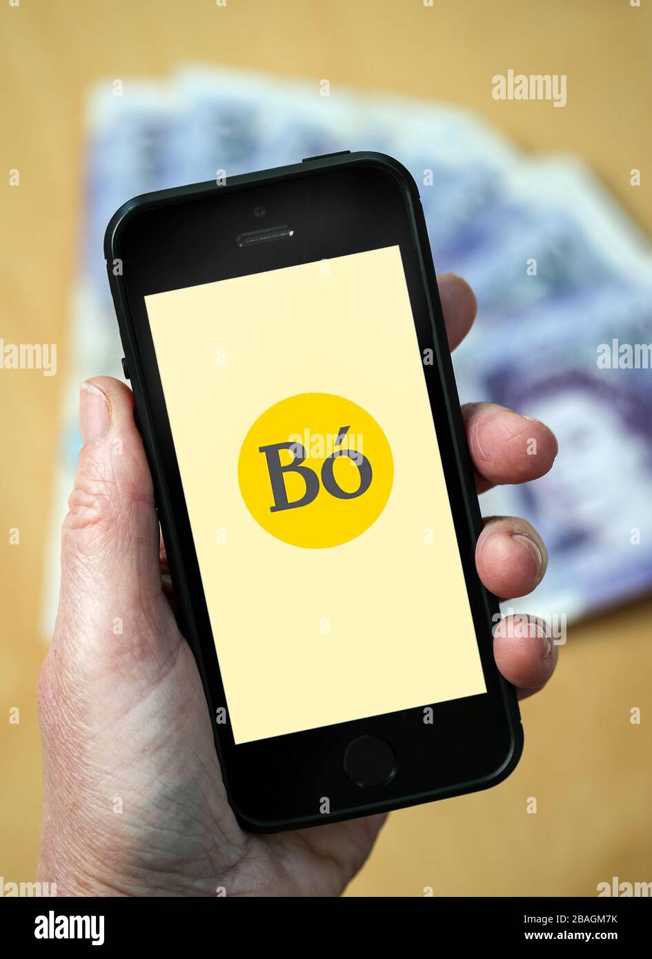 Eine Frau, die das Logo der Bo Banking App auf einem Mobiltelefon betrachtet. (Nur redaktionelle Verwendung) Stockfoto