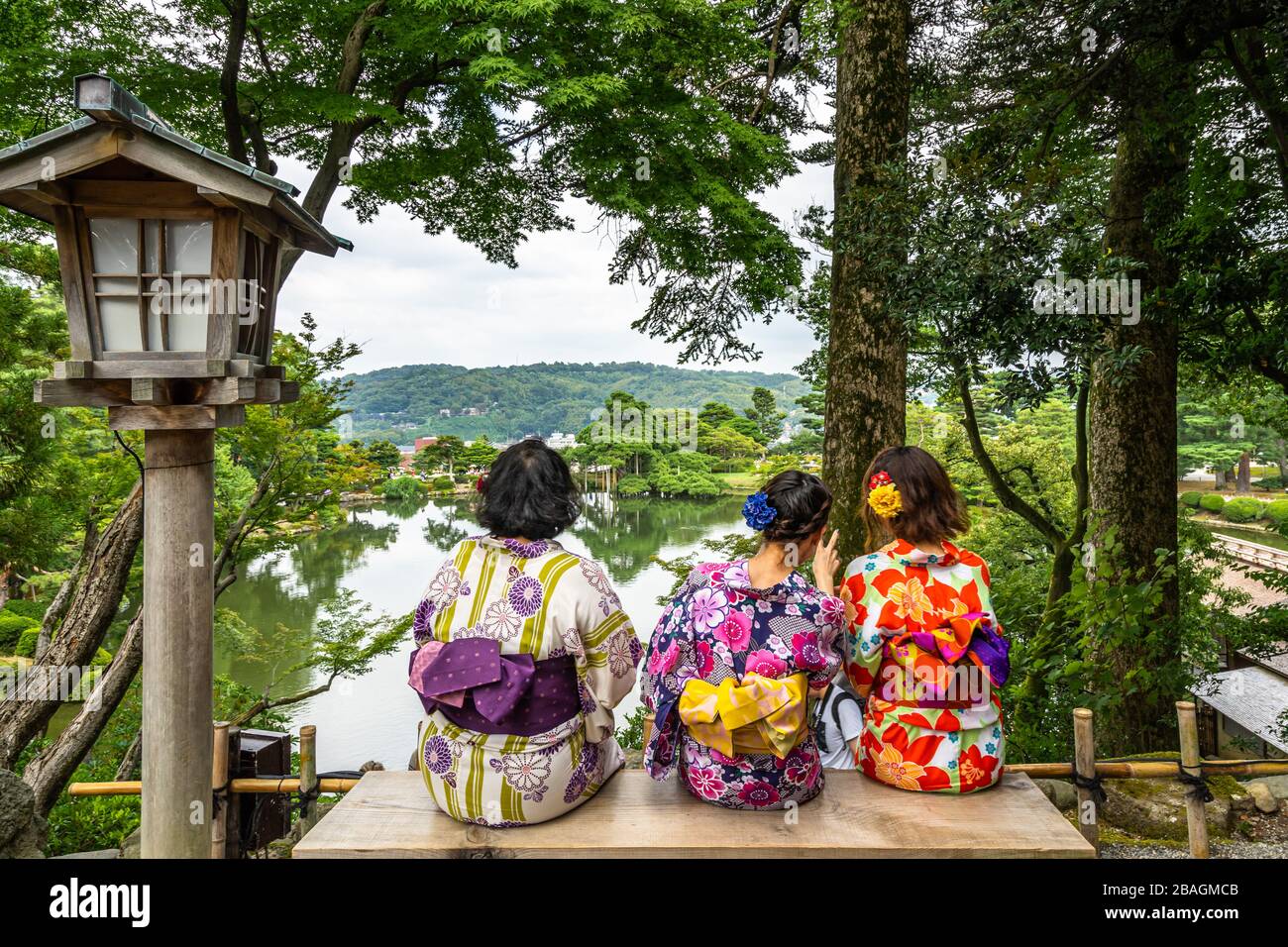 Frauen, die traditionelles japanisches Kleid tragen, sitzen auf einer Bank im Kenrokuen Garden, Kanazawa, Japan Stockfoto