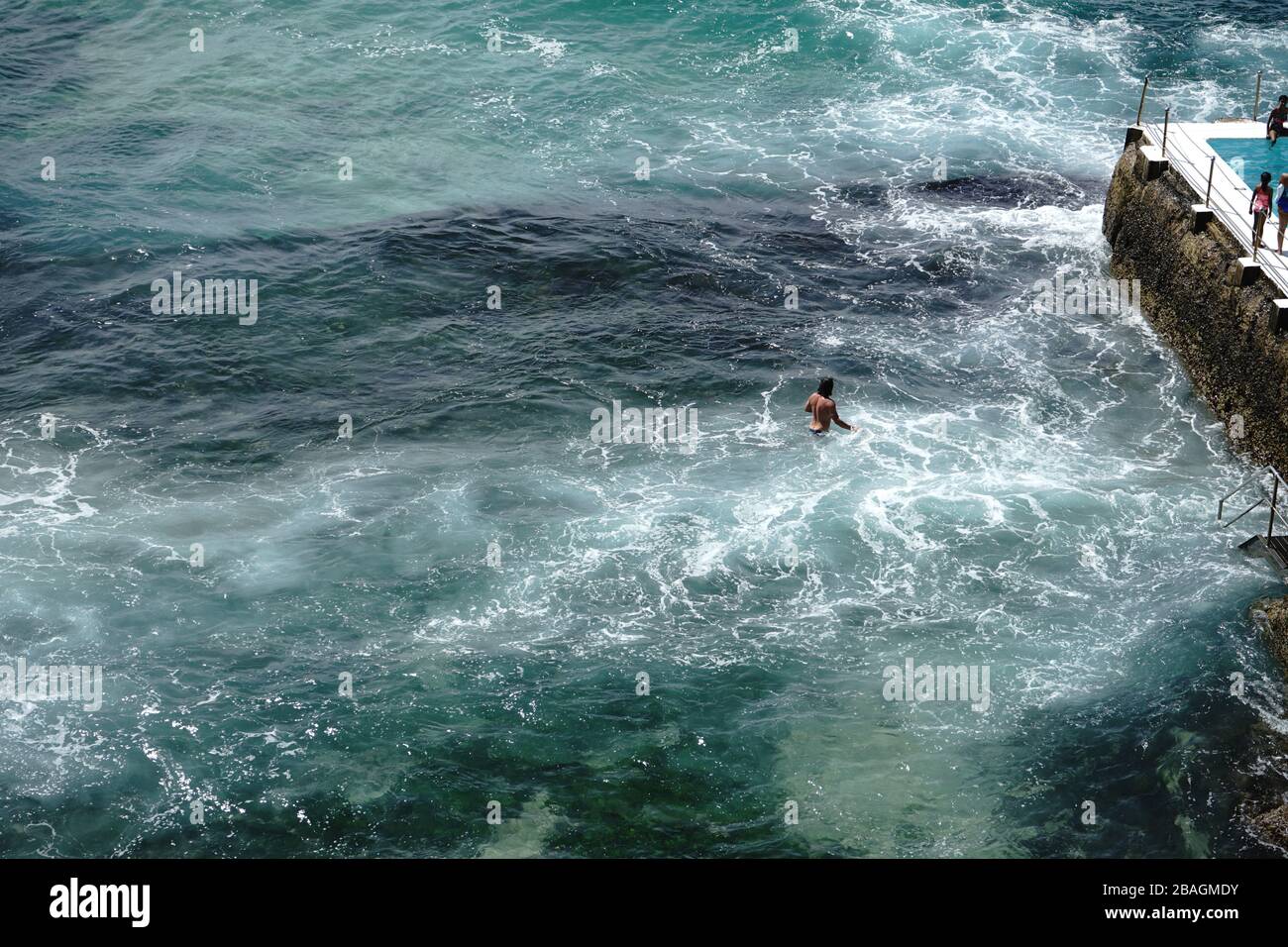 Maskuliner Mann watend im Meerwasser am Bondi Beach, Sydney. Stockfoto