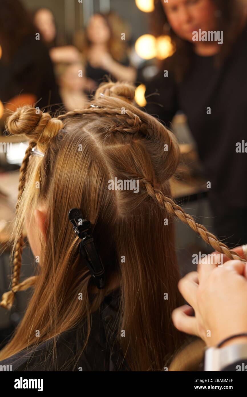 Frisierin flechten junge Frauenhaare für eine Modenschau während der NYFW Stockfoto