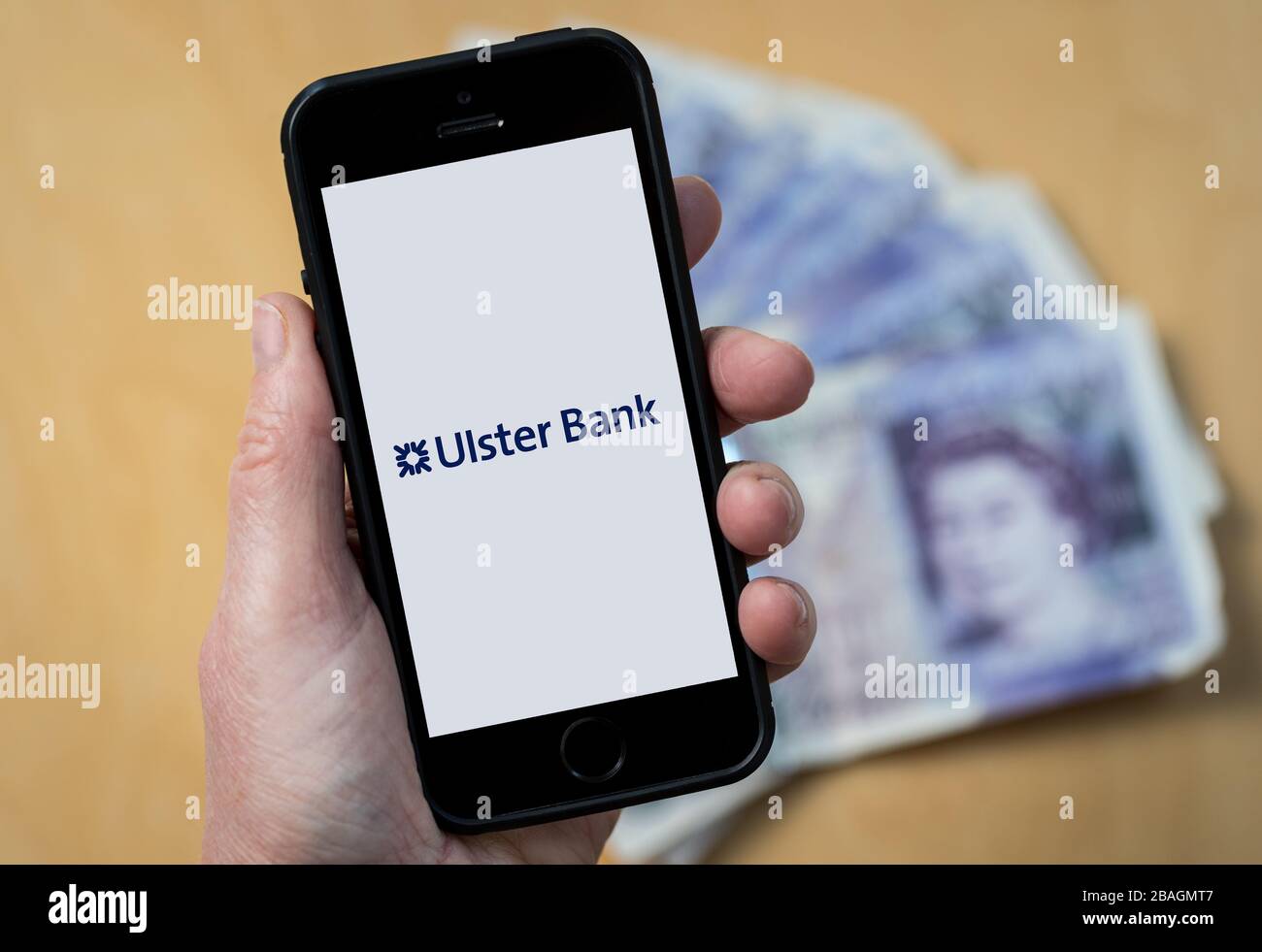 Eine Frau, die das Logo der Ulster Bank auf einem Mobiltelefon betrachtet. (Nur redaktionelle Verwendung) Stockfoto