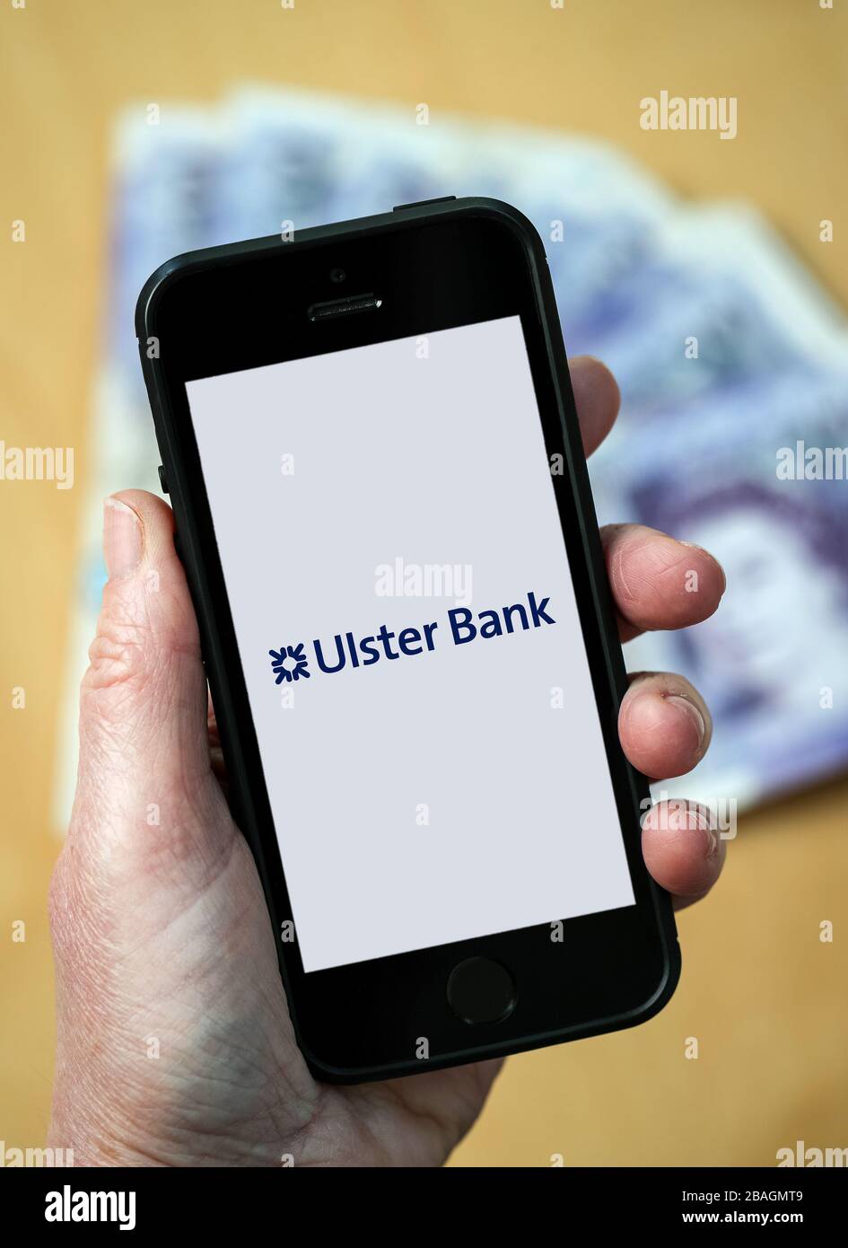 Eine Frau, die das Logo der Ulster Bank auf einem Mobiltelefon betrachtet. (Nur redaktionelle Verwendung) Stockfoto
