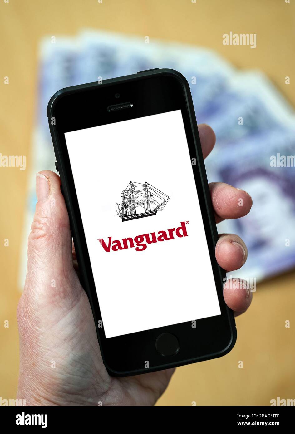 Eine Frau, die das Logo der Vanguard Fund Management Company auf einem Handy betrachtet. (Nur redaktionelle Verwendung) Stockfoto